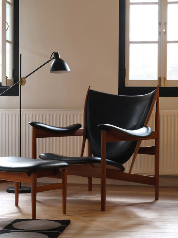 Høvdingeskamlen i valnød polstret med 'Elegance' læder i farven 'Black'.