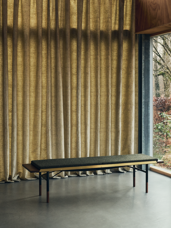 Bordbænken i valnød med sorte stålben og messingkanter. Hynden er polstret med 'Nalia' tekstil i farven '990'. Foto: Elisabeth Heltoft for Sahco