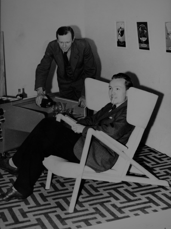 Finn Juhl fotograferet i Græshoppestolen på Snedkerlaugetsudstilling i 1938.
